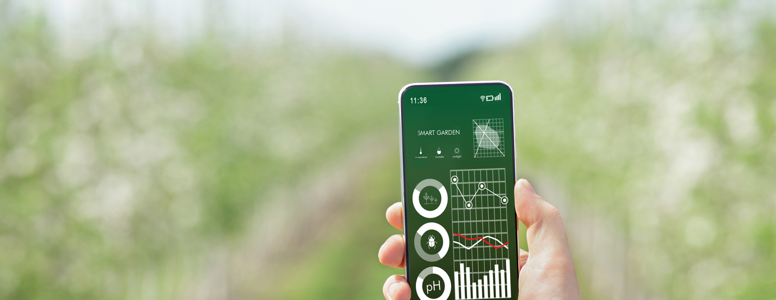 A man holding a phone in front of a field
